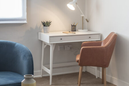 Counselling room with desk and pastel colour scheme