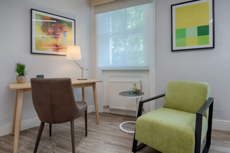 Spacious therapy room with office desk and comfortable client chairs